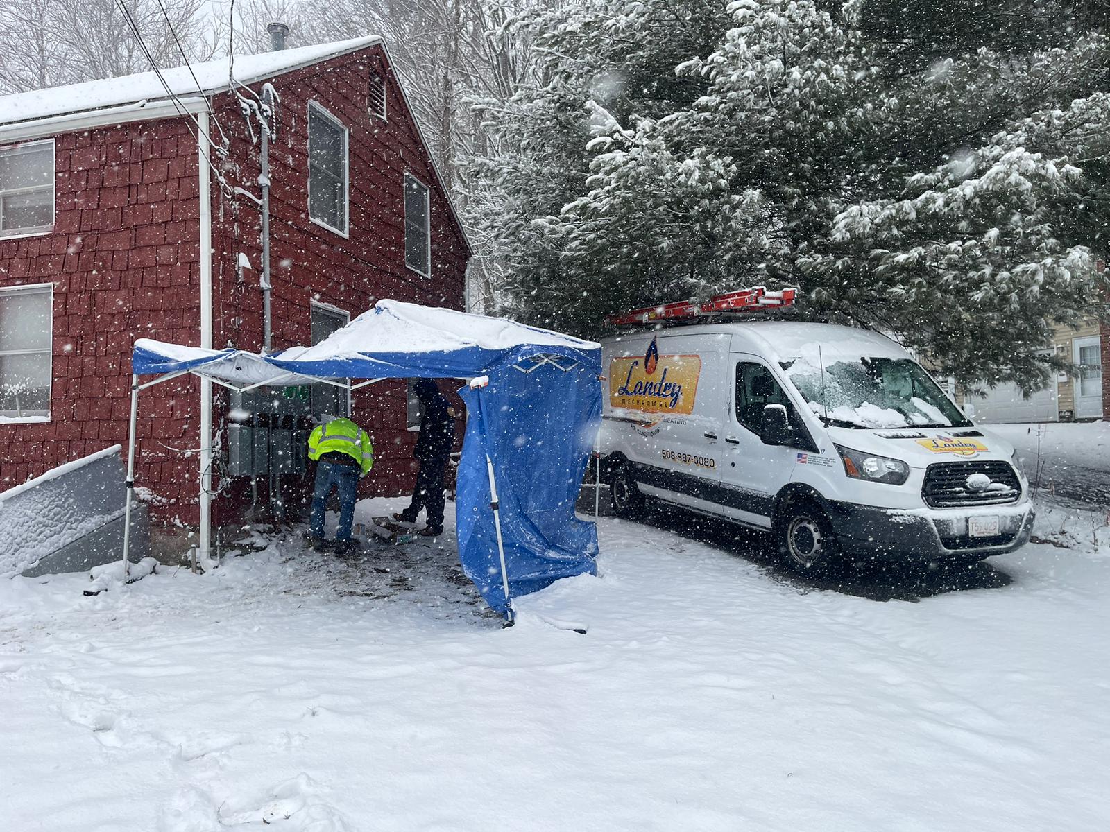 Landry Team Repairing Heat Pump System During Snow Storm