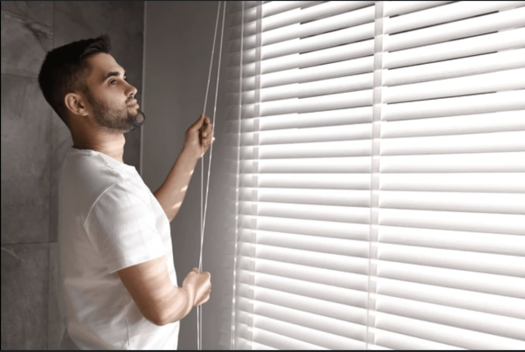 Man Closing Blinds During a Heatwave 