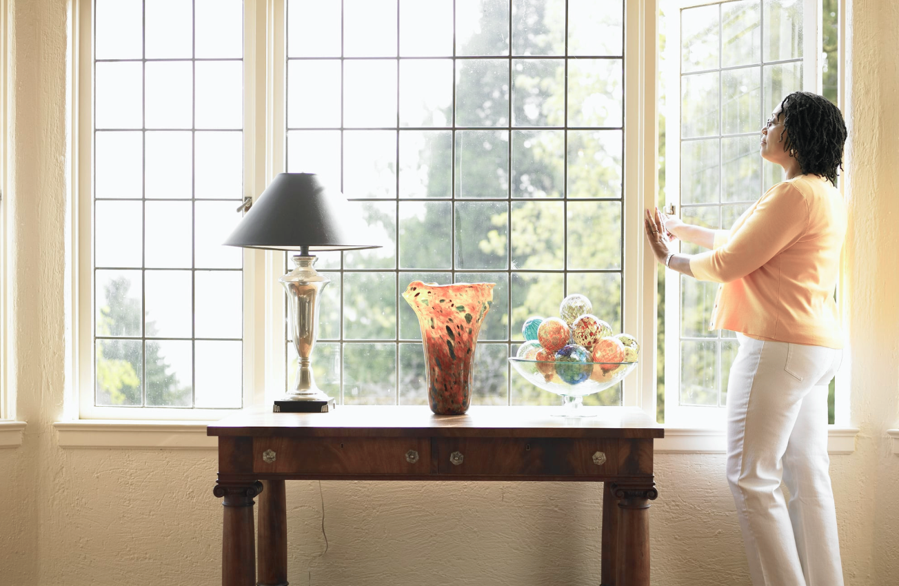 Woman Opening Window On A Sunny Day