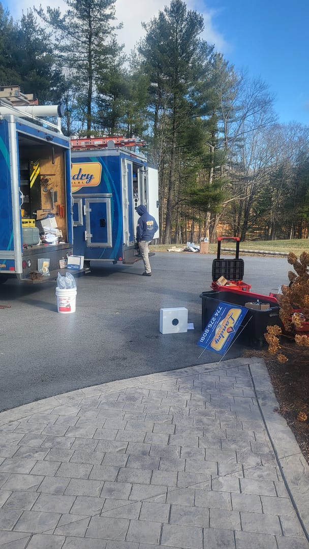 Landry team unloading equipment from truck onto a driveway in preparation of an appointment.