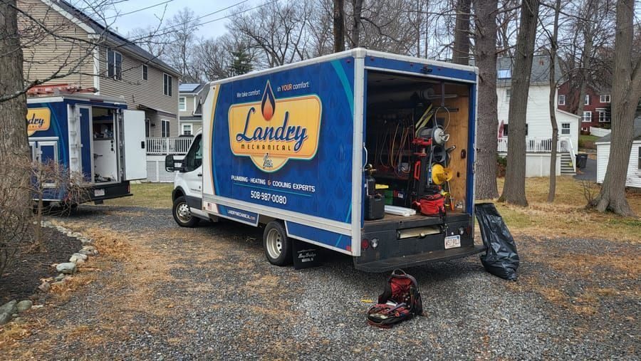 Blue Landry Mechanical service van with tools visible in the open rear, parked in a driveway.
